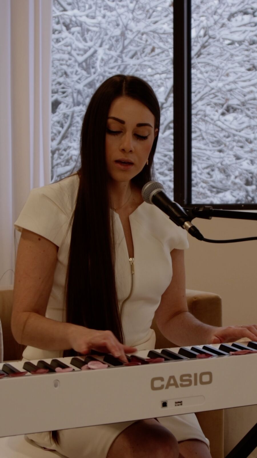Regina Bianca at a piano in soft natural light